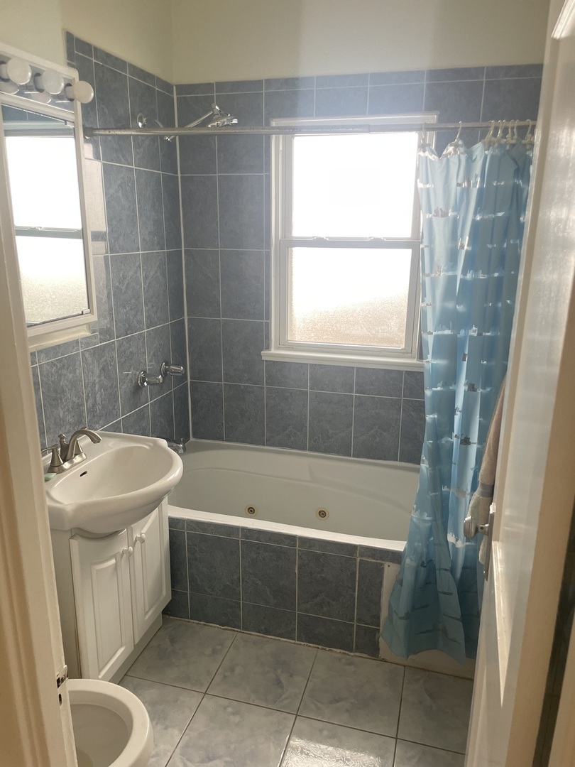 Undisclosed Address Forest Park, IL 60130 - Photo 6 of 16 a bathroom with a sink a toilet a bathtub and shower