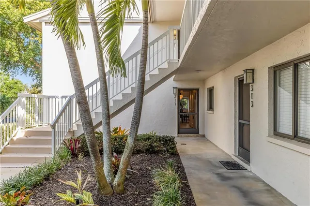 a view of a pathway of a house with plants and wooden fence