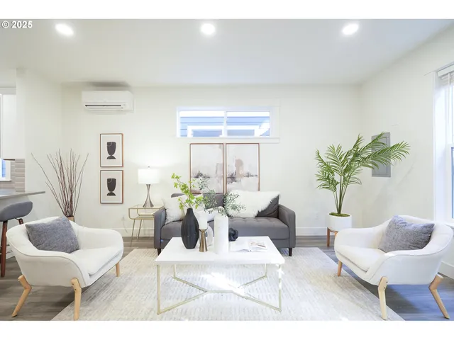 a living room with furniture a window and a potted plant