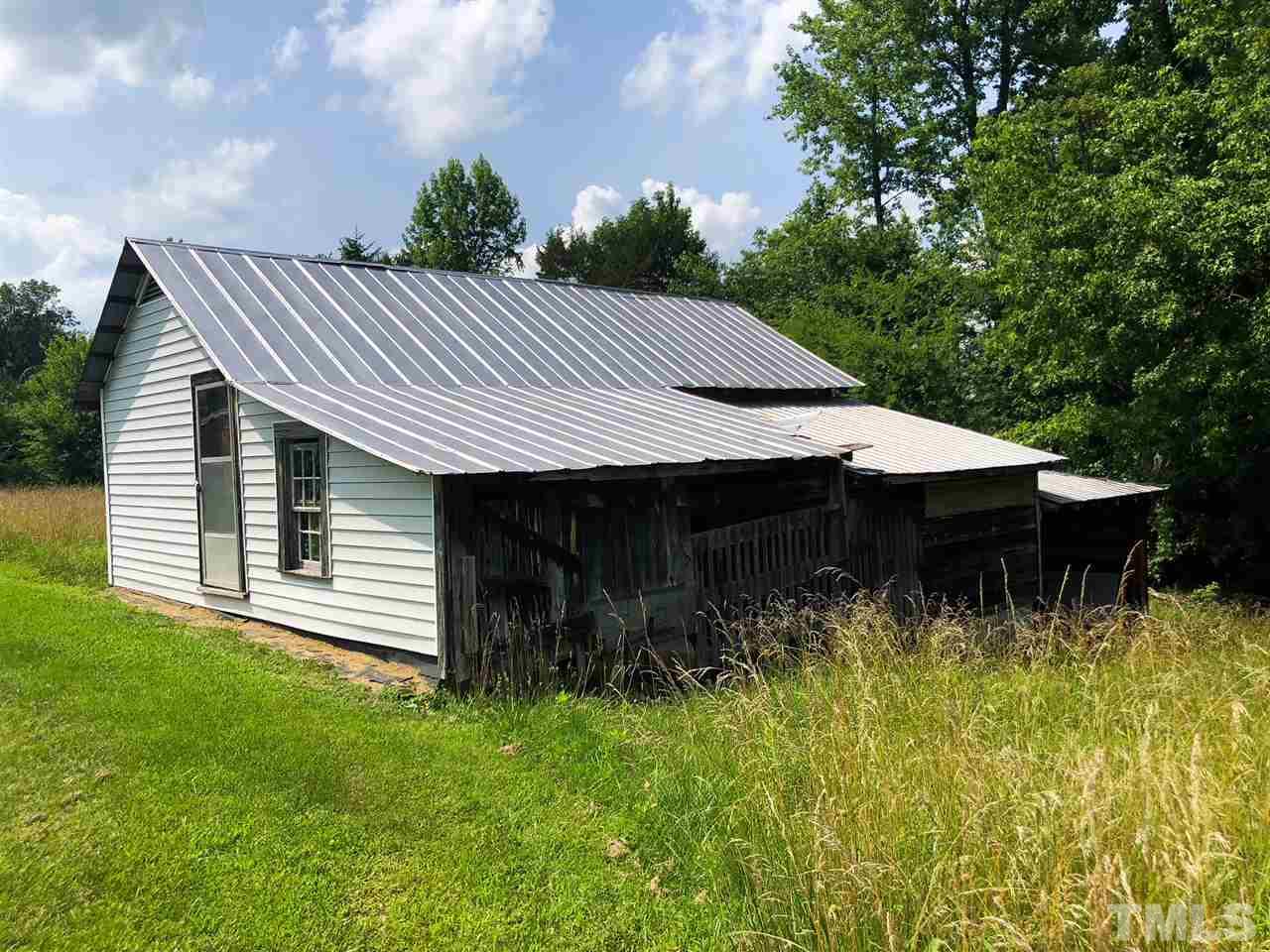 894 Shiloh Church Road Roxboro, NC 27574 - Photo 24 of 24 a backyard of a house with yard plants and large tree