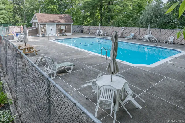 a view of a patio with chairs and wooden fence
