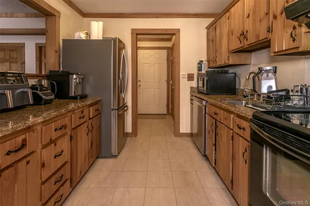 a kitchen with stainless steel appliances granite countertop a refrigerator stove and sink