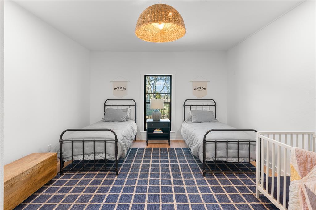 990 Cornelius Road Rockwall, TX 75087 - Photo 25 of 37 a bedroom with two beds and a chandelier