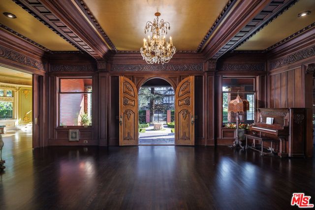 a view of a livingroom with furniture chandelier fireplace and windows