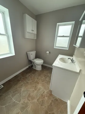 a bathroom with a sink toilet and window