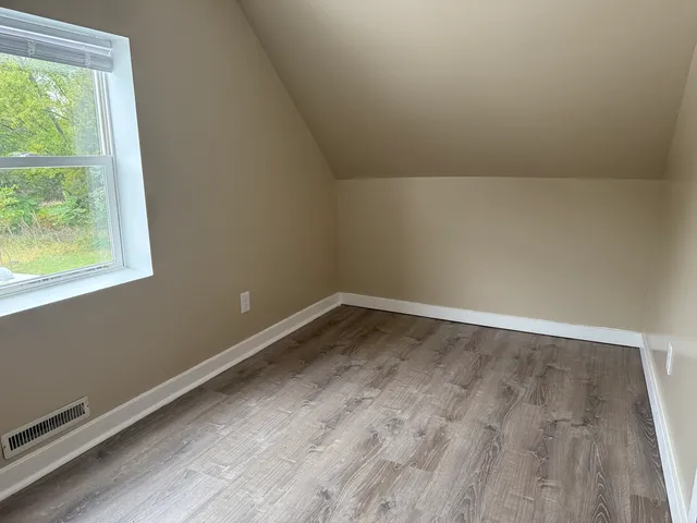 a view of a room with wooden floor and window