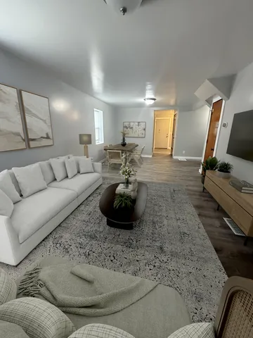 a living room with furniture and a wooden floor