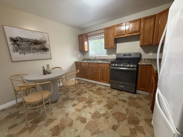 a kitchen with stainless steel appliances granite countertop a stove a sink and a microwave