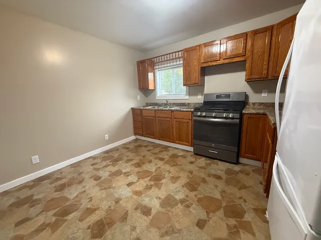 a kitchen with granite countertop a stove top oven and sink