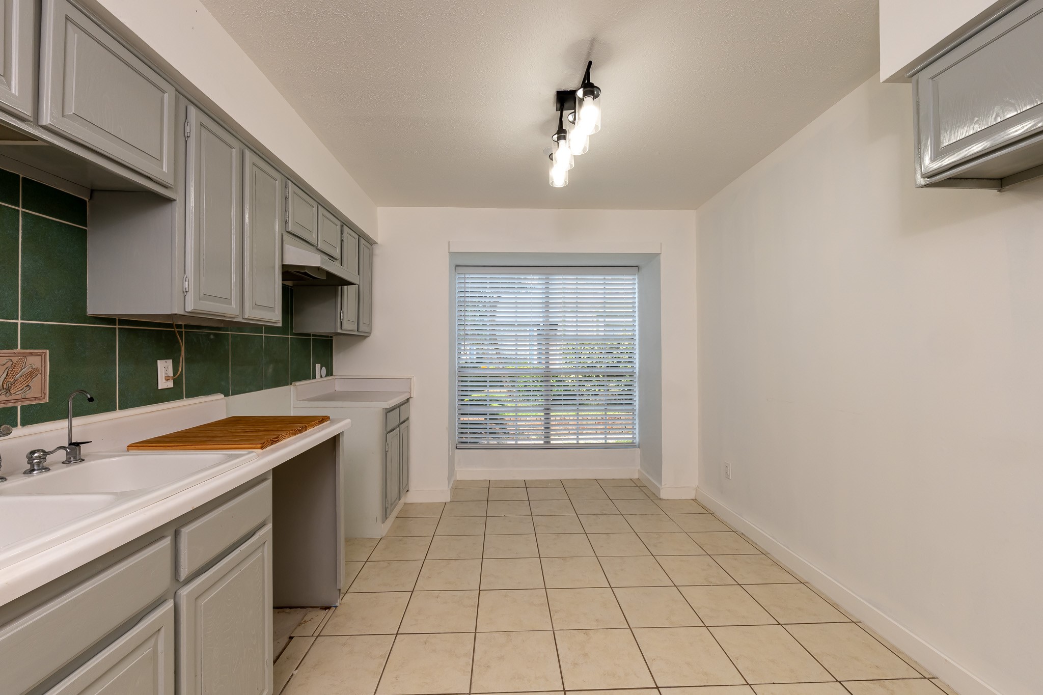 8486 Ariel Street Houston, TX 77074 - Photo 16 of 45 a kitchen with a sink a stove cabinets and utility room