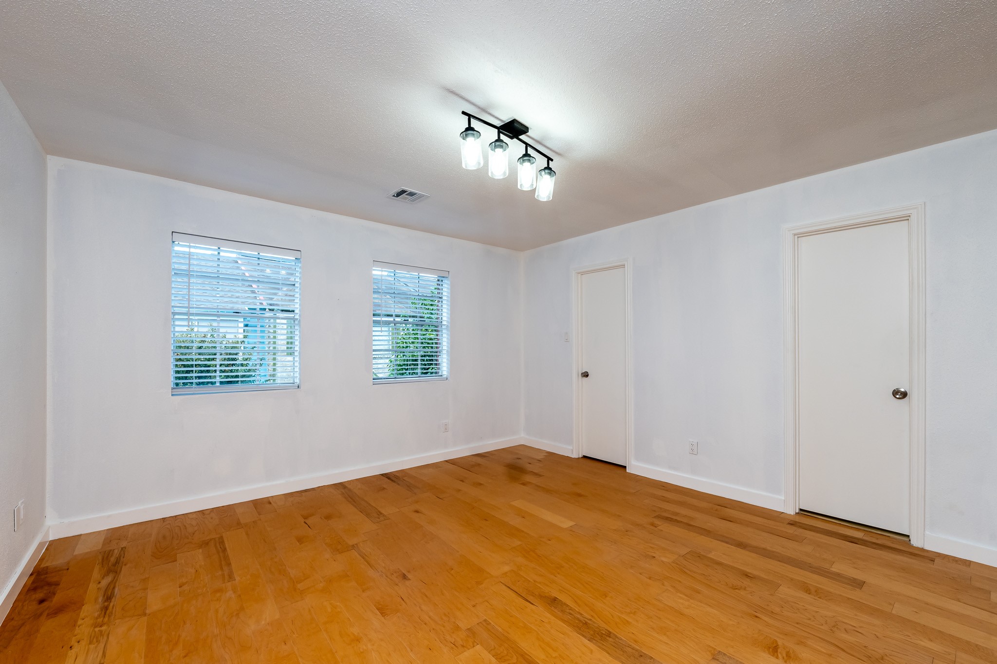 8486 Ariel Street Houston, TX 77074 - Photo 33 of 45 a bedroom with a large bed and a chandelier