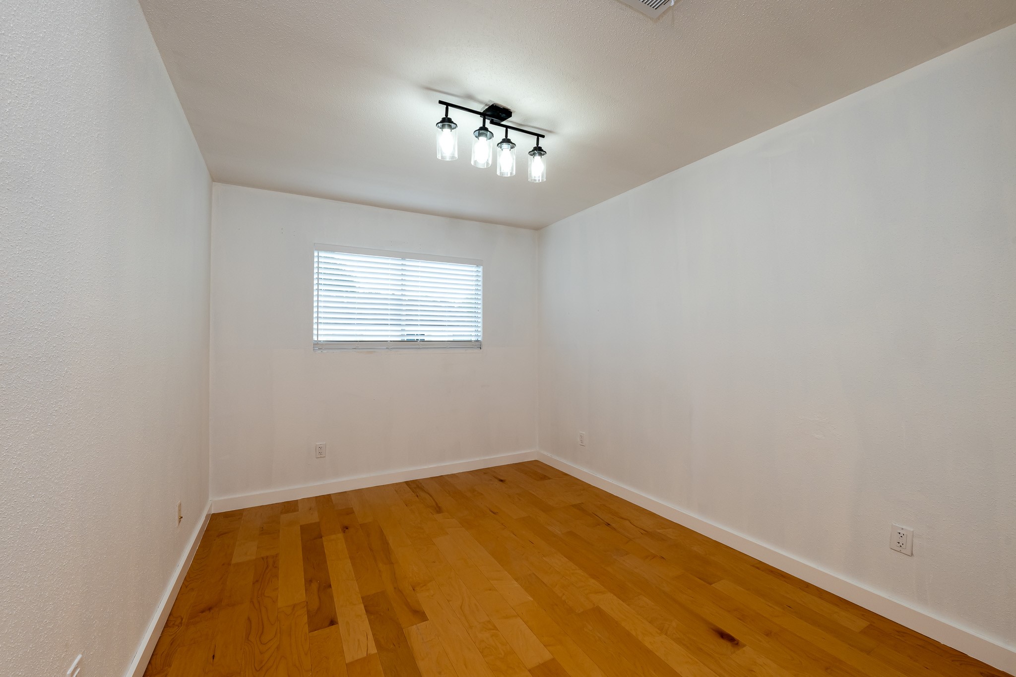 8486 Ariel Street Houston, TX 77074 - Photo 42 of 45 an empty room with a chandelier fan and a window