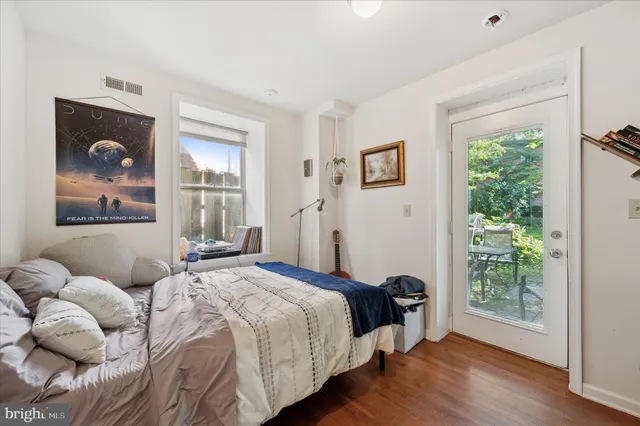 a bedroom with a bed and a painting on the wall