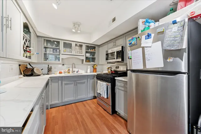 a kitchen with stainless steel appliances granite countertop a refrigerator sink and stove