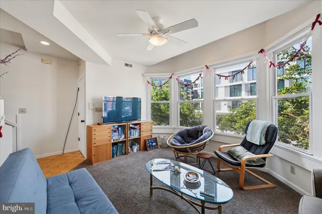 a living room with furniture a flat screen tv and a large window