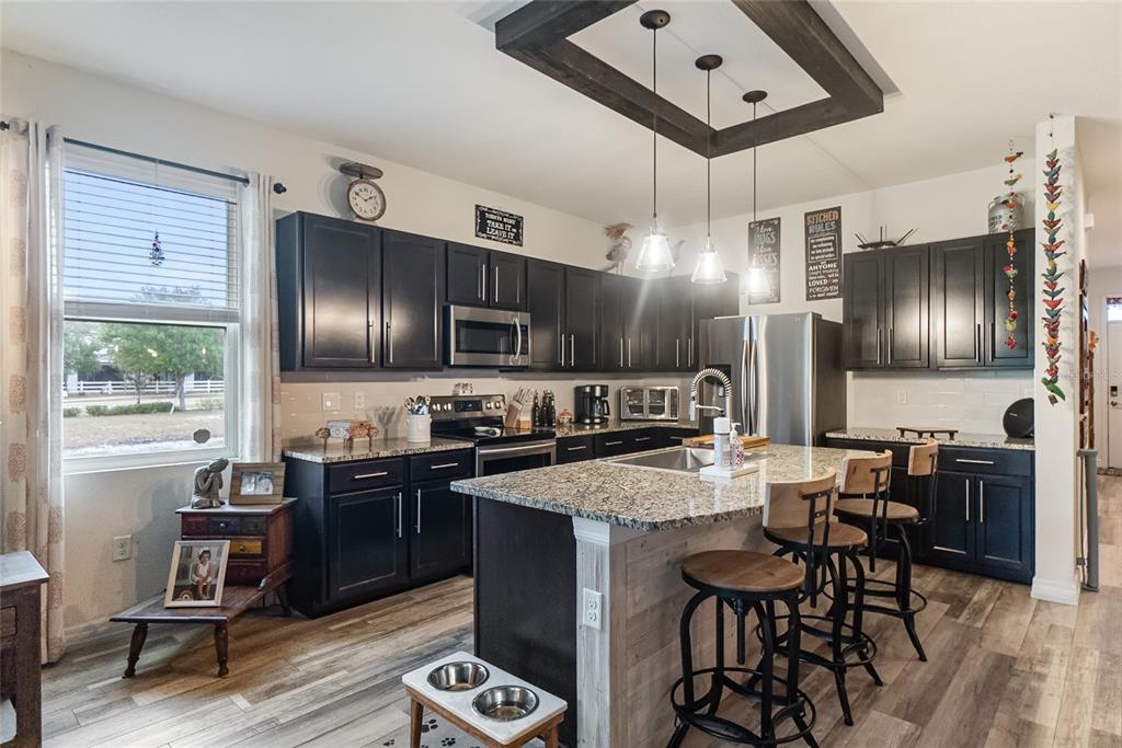 8990 Indigo Trail Loop Riverview, FL 33578 - Photo 11 of 43 a kitchen with granite countertop a sink stove and refrigerator