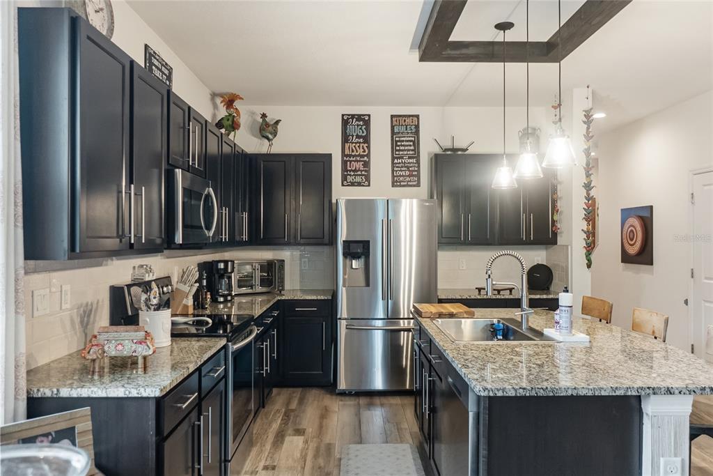 8990 Indigo Trail Loop Riverview, FL 33578 - Photo 13 of 43 a kitchen with stainless steel appliances granite countertop a sink stove and refrigerator