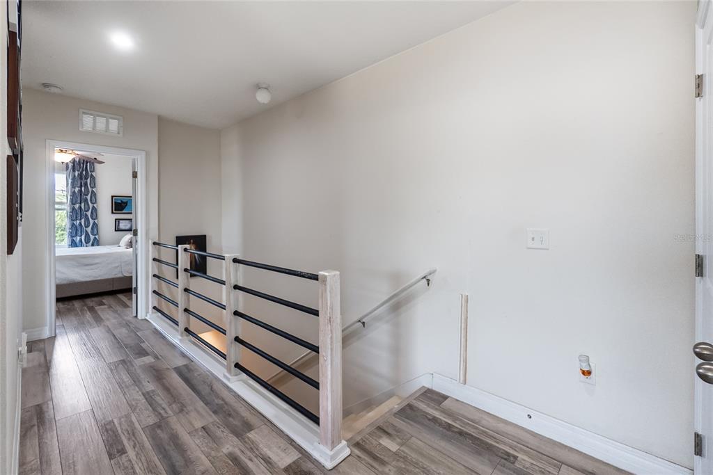 8990 Indigo Trail Loop Riverview, FL 33578 - Photo 20 of 43 a view of a hallway with stairs and wooden floor