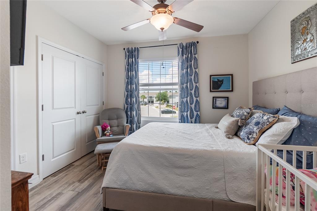 8990 Indigo Trail Loop Riverview, FL 33578 - Photo 25 of 43 a bedroom with a bed and a chandelier