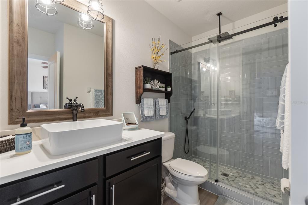 8990 Indigo Trail Loop Riverview, FL 33578 - Photo 27 of 43 a bathroom with a sink toilet a mirror and shower