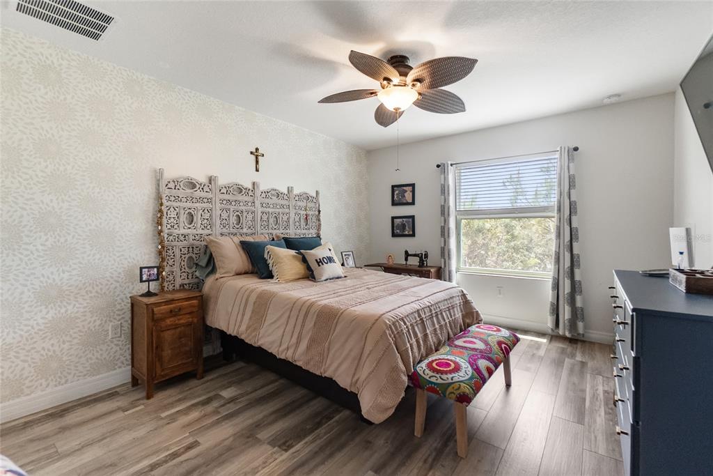 8990 Indigo Trail Loop Riverview, FL 33578 - Photo 30 of 43 a bedroom with a bed and wooden floor