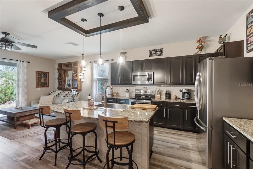 8990 Indigo Trail Loop Riverview, FL 33578 - Photo 9 of 43 a kitchen with granite countertop a sink appliances cabinets and furniture