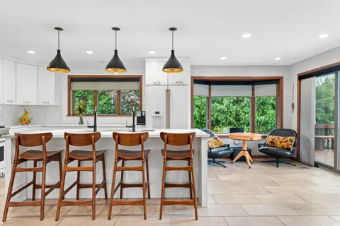 a dinning table and chairs in a room with a flat screen tv