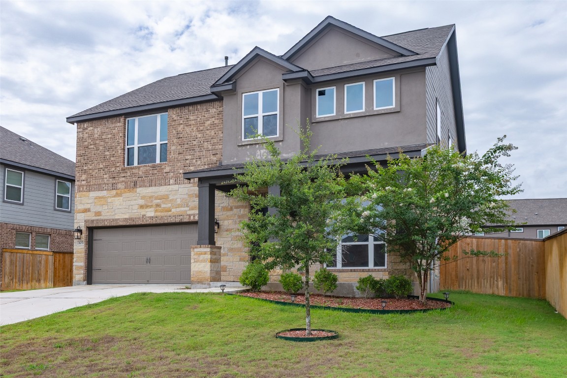 103 Periwinkle Lane Bastrop, TX 78602 - Photo 1 of 35 a front view of a house with a yard and garage