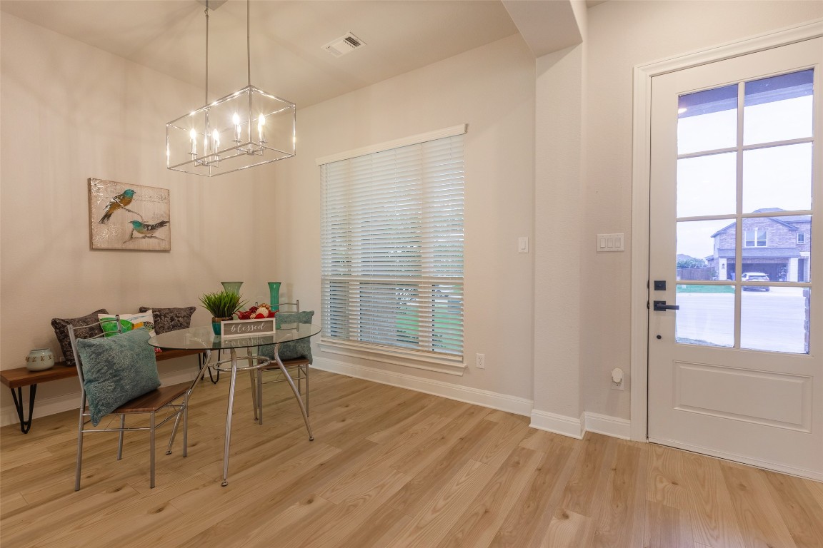 103 Periwinkle Lane Bastrop, TX 78602 - Photo 12 of 35 a view of a dining room with furniture a chandelier and wooden floor