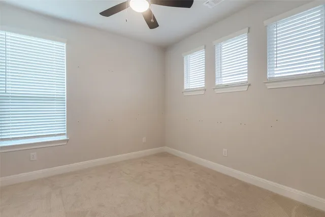 an empty room with a window and a ceiling fan