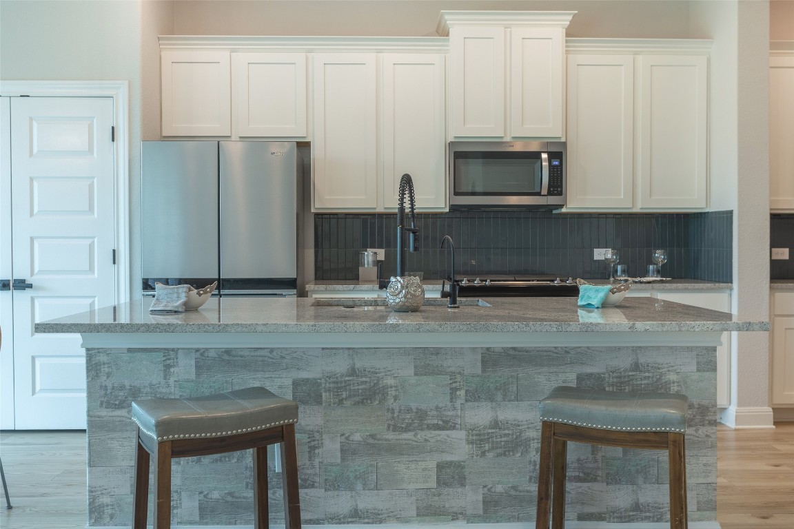 103 Periwinkle Lane Bastrop, TX 78602 - Photo 26 of 35 a kitchen with stainless steel appliances granite countertop a sink a stove and a microwave