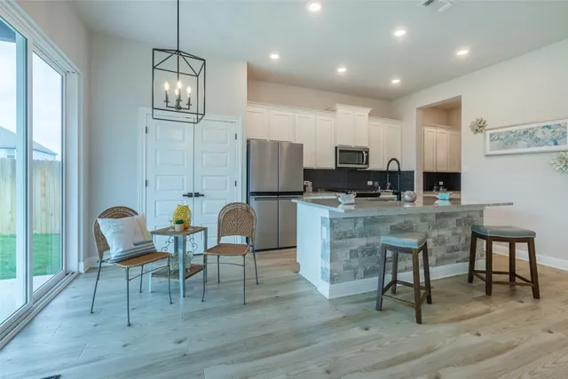 a living room with stainless steel appliances kitchen island granite countertop furniture and a wooden floor