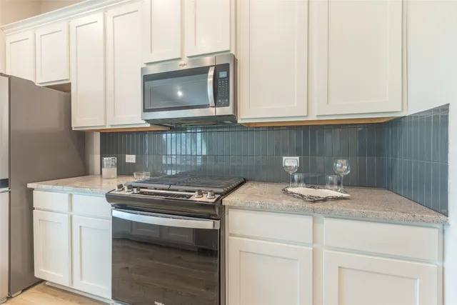 a kitchen with stainless steel appliances granite countertop a sink stove and microwave