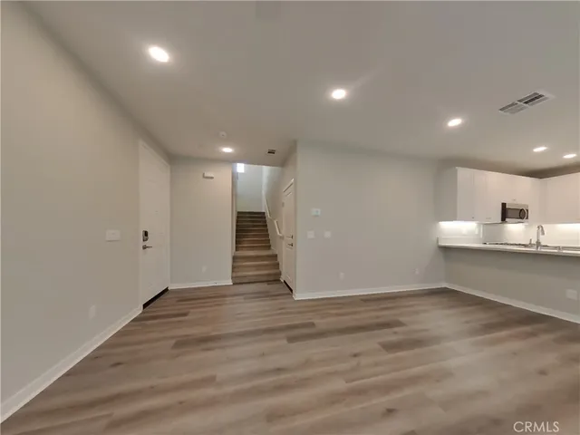 a view of a room with wooden floor and a window