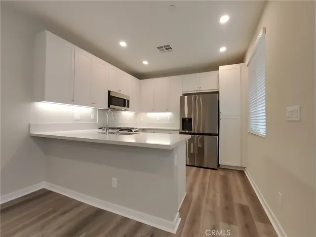a kitchen with stainless steel appliances granite countertop a refrigerator and a sink