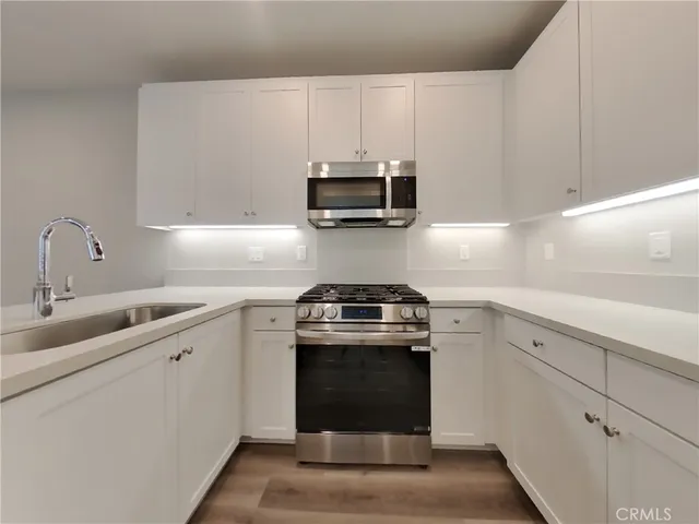 a kitchen with granite countertop a stove and a sink