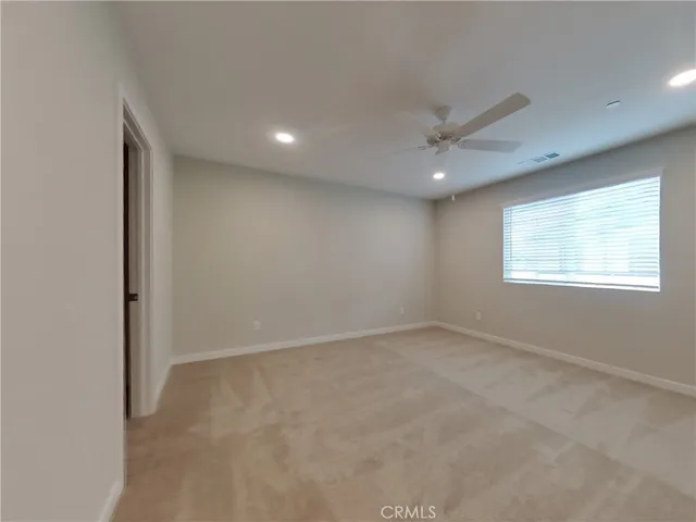 an empty room with windows and fan