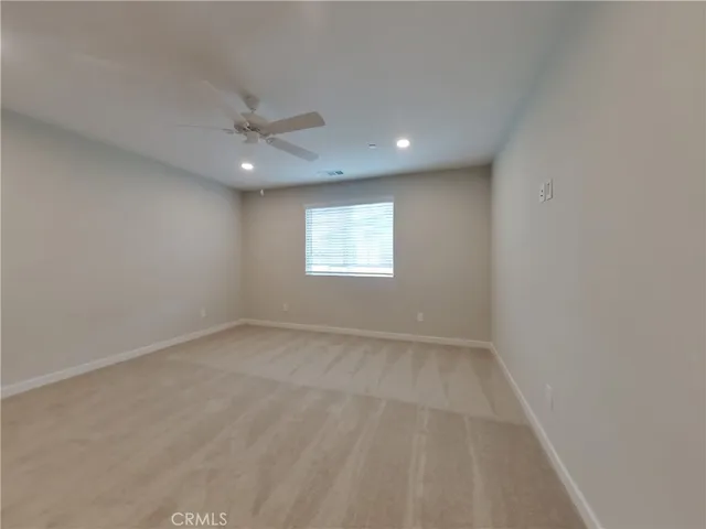 an empty room with a window and a ceiling fan