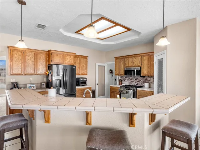a large kitchen with kitchen island a sink a counter top space and appliances