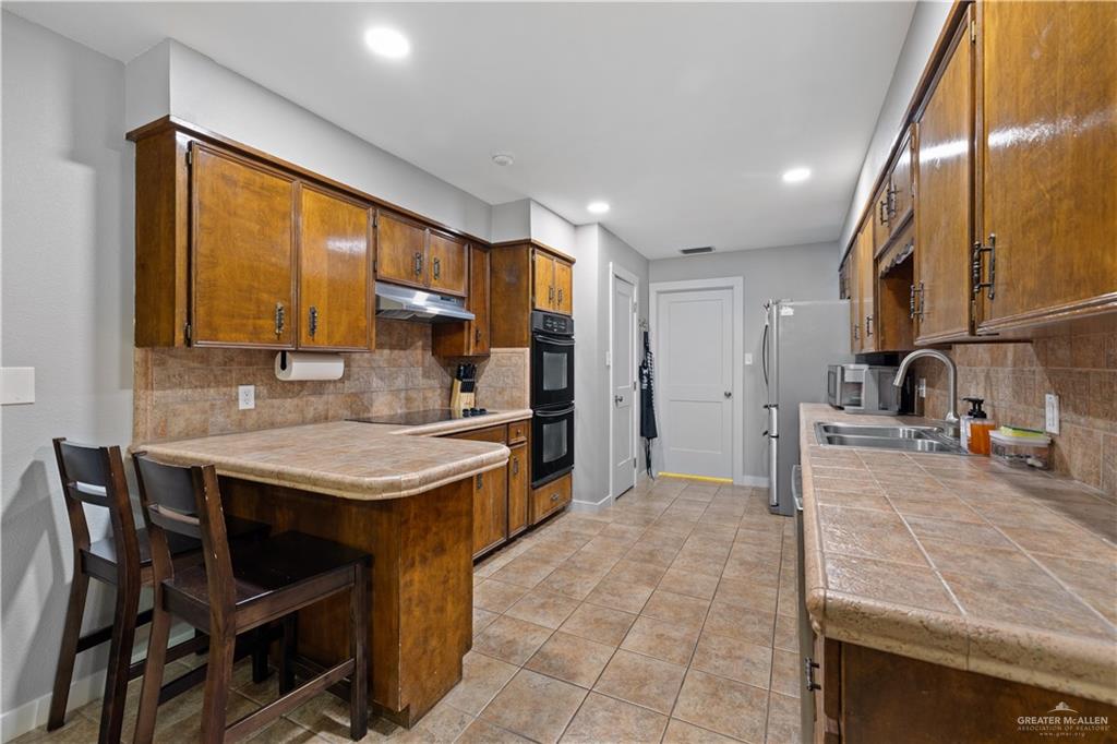 2212 North Bryan Rd Mission Mission, TX 78572 - Photo 10 of 44 a kitchen with stainless steel appliances granite countertop a stove a sink and a refrigerator