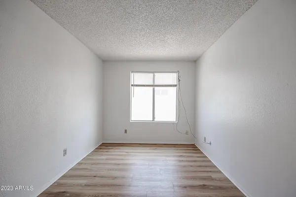 an empty room with wooden floor and window