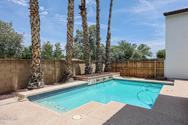 a view of a swimming pool with a yard and sitting area