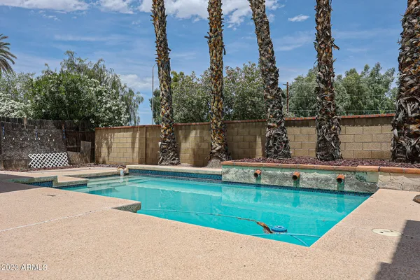 a view of a house with swimming pool and sitting area