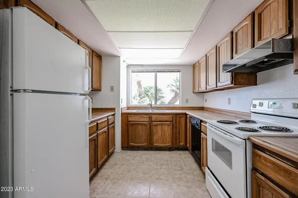 a kitchen with stainless steel appliances granite countertop a stove a refrigerator and a sink