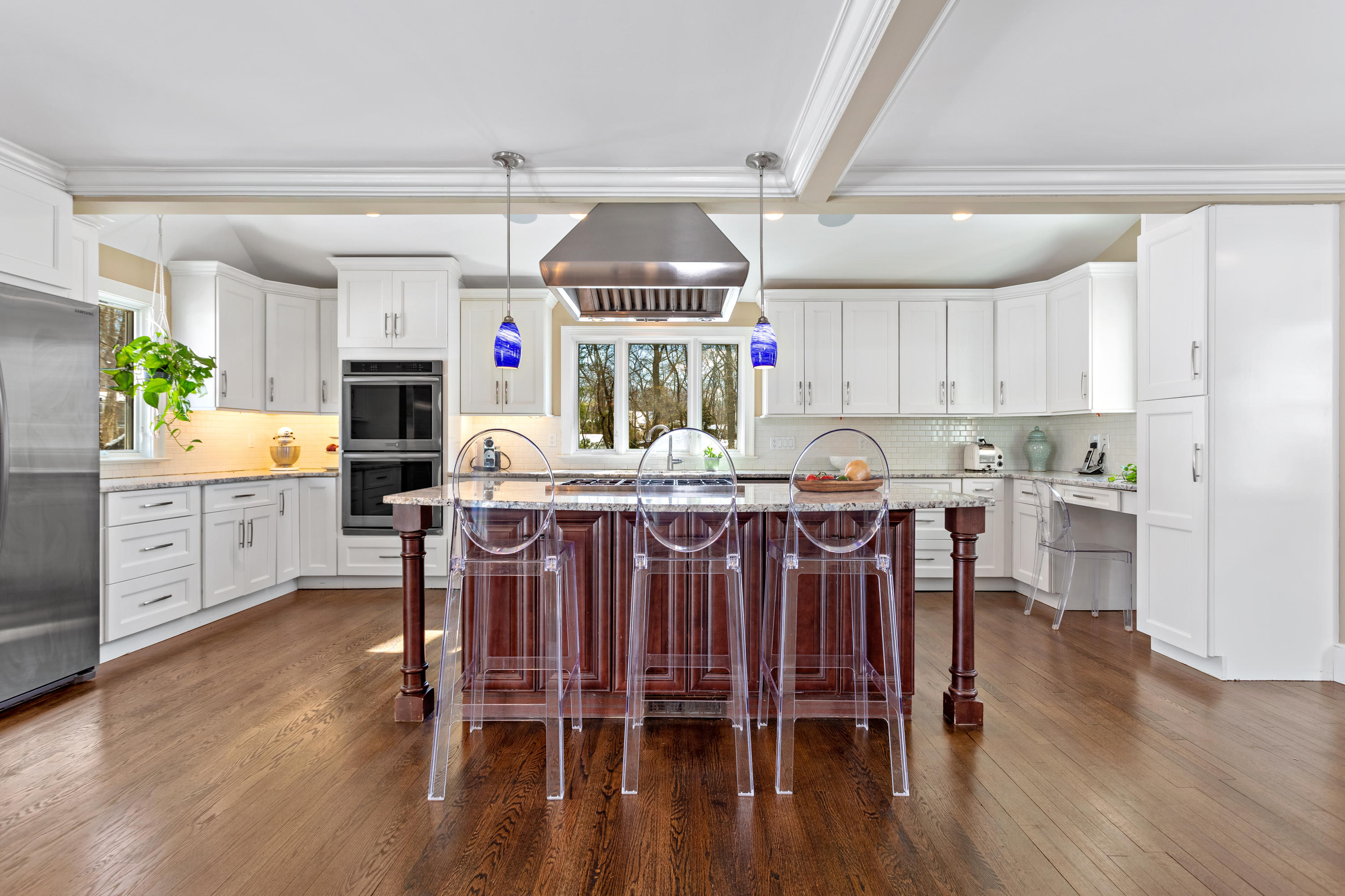 10 Little Brook Road Rowayton, CT 06853 - Photo 6 of 16 a kitchen with stainless steel appliances a dining table chairs refrigerator and sink