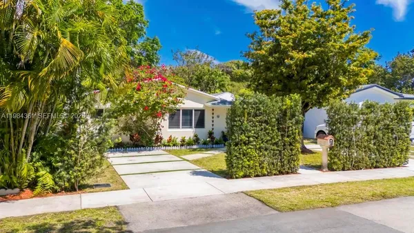 a view of a house with backyard and sitting area