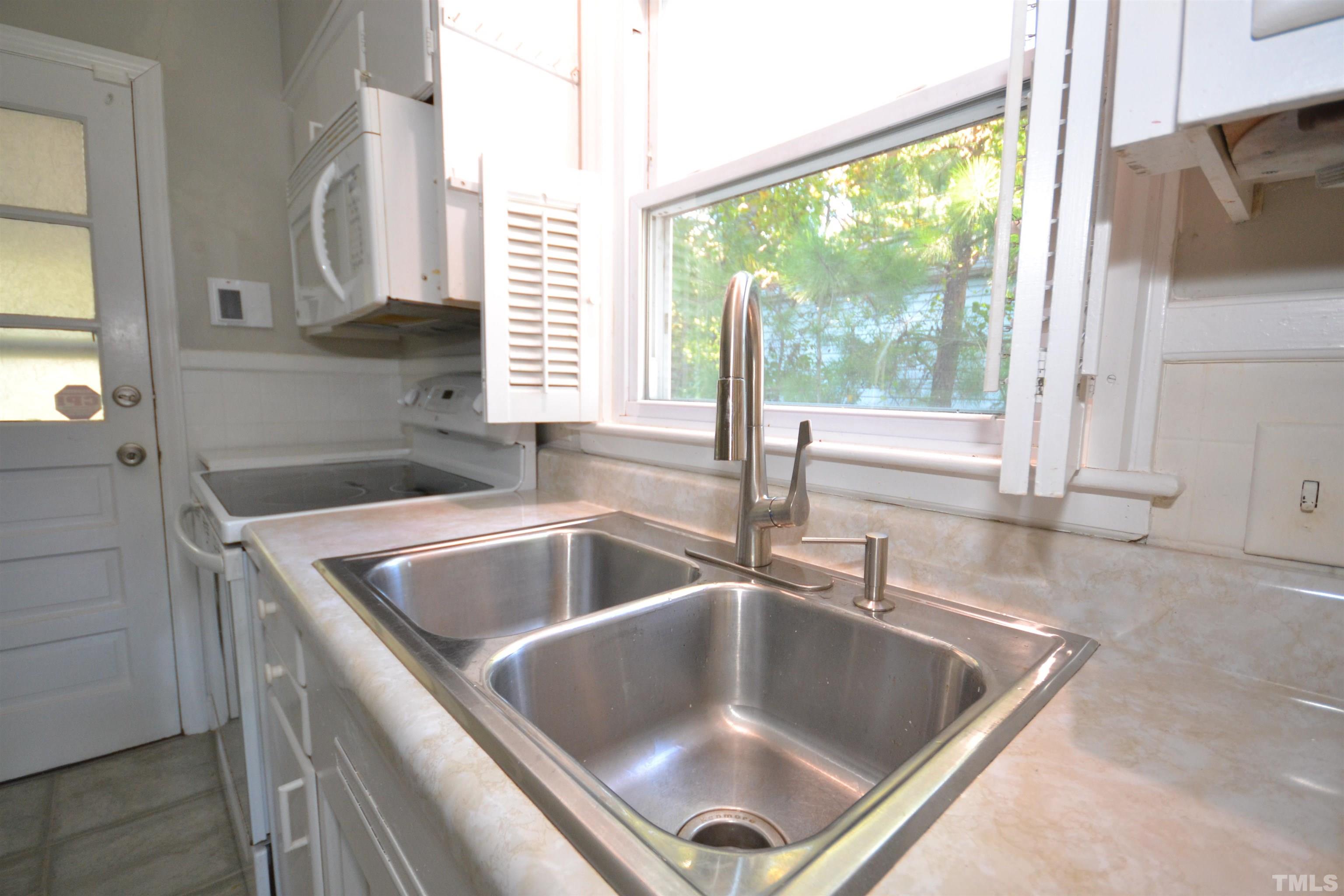 1713 Forest Road Durham, NC 27705 - Photo 22 of 35 a kitchen with granite countertop a sink and a window
