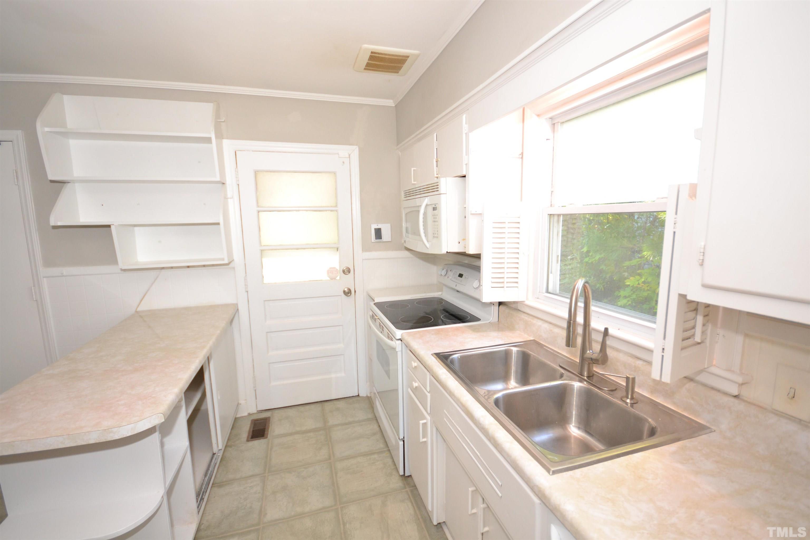 1713 Forest Road Durham, NC 27705 - Photo 8 of 35 a kitchen with a sink a stove and a refrigerator