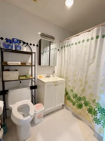 a bathroom with a sink a toilet and shower curtain