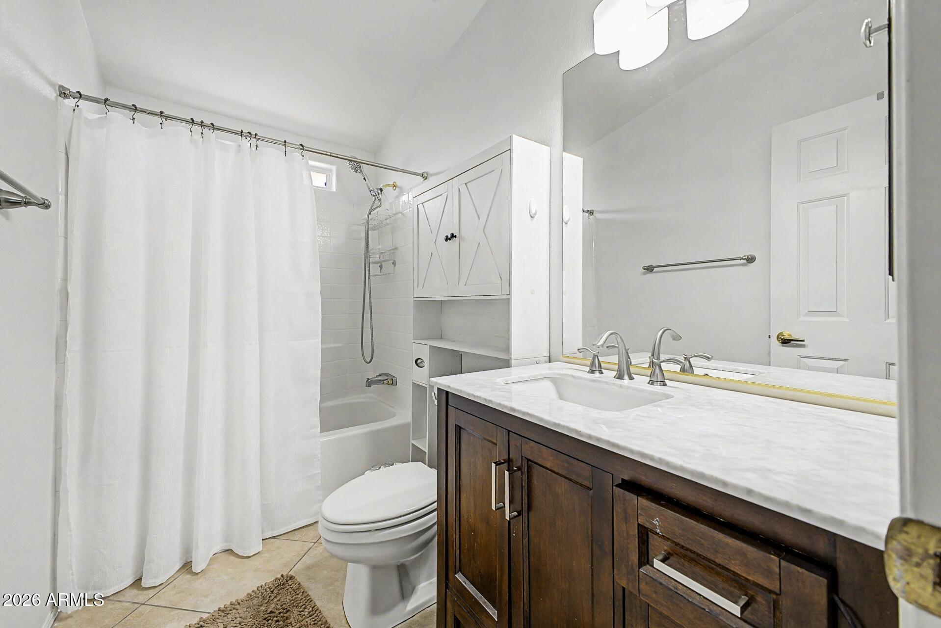 2550 South Ellsworth Road, Unit 46 Mesa, AZ 85209 - Photo 24 of 46 a bathroom with a sink a toilet and shower curtain